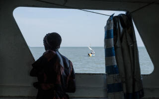 A woman looks at the sea on the ferry boat sailing from Luanda K’Otieno to Mbita on Lake Victoria in western Kenya, on October 4, 2018. - The sinking of the MV Nyerere two weeks ago, just over 200 kilometres (124 miles) away in Tanzanian waters, highlighted the risks for the thousands of residents on the shores and islands of the lake, forced to use overcrowded or poorly maintained boats to go about their business, in a region where few know how to swim. (Photo by Yasuyoshi CHIBA / AFP)
