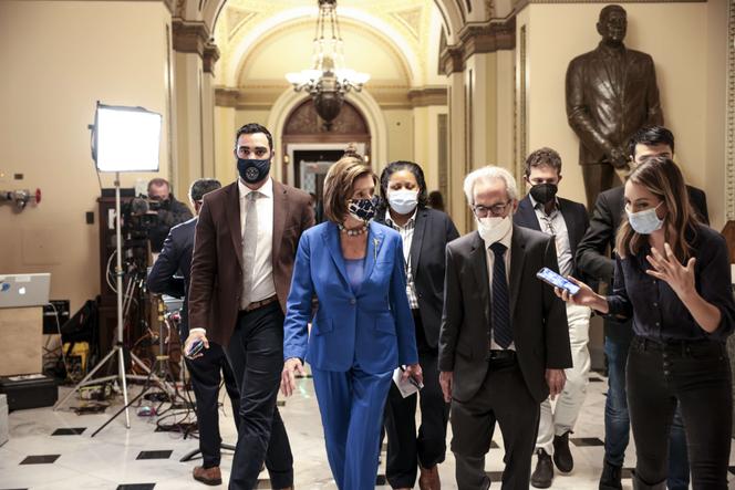 La présidente démocrate de la Chambre des représentants, Nancy Pelosi, dans les couloirs du Capitole avec des journalistes, le 12 octobre 2021, à Washington.
