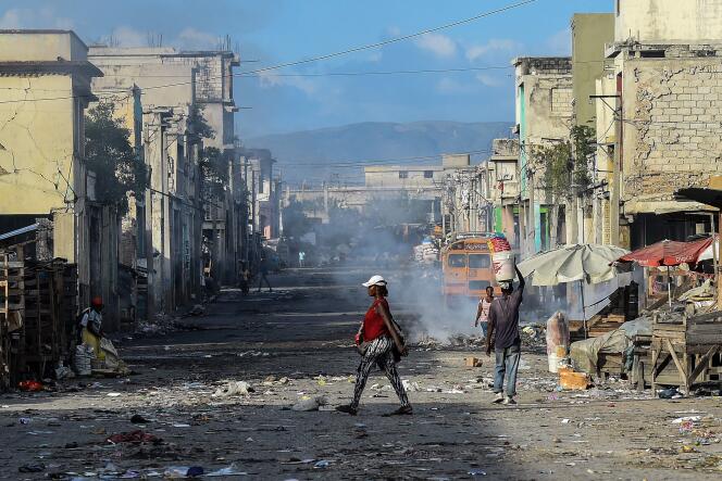 In downtown, Port-au-Prince residents walk down a deserted road between two shootings between gangs in Haiti in December 2019.