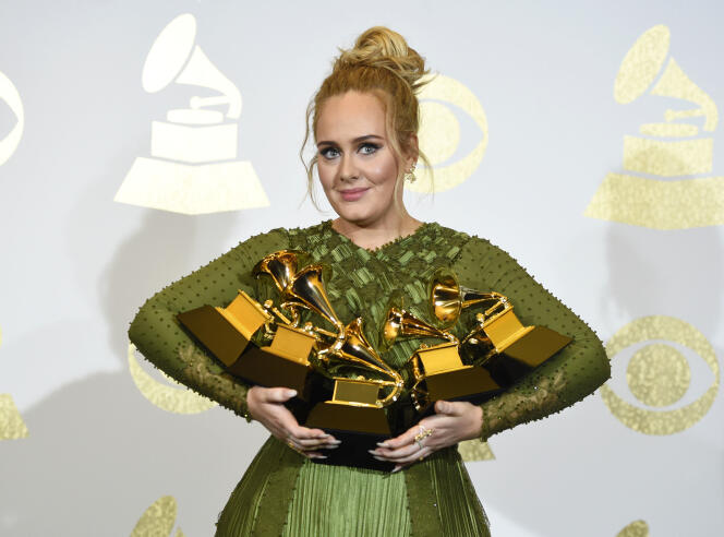 Adele tient les prix reçus pour son album « 25 », lors des Grammy Awards, à Los Angeles, en 2017.
