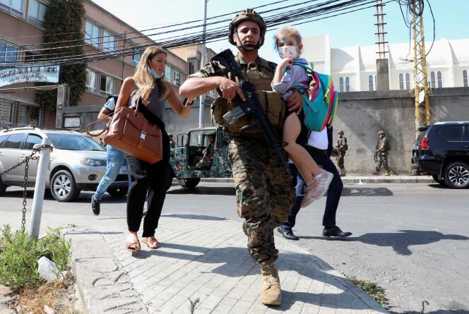 Un soldat libanais accompagne des civils fuyant les échanges de tirs, à Beyrouth, le 14 octobre 2021.