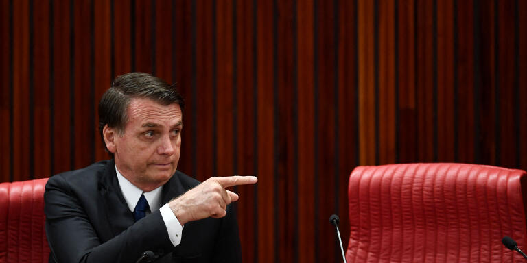 Brazilian President-elect Jair Bolsonaro delivers gestures during a ceremony in which he received a diploma that certifies he can take office as president from Electoral Supreme Court (TSE) president Justice Rosa Weber, at the TSE in Brasilia, on December 10, 2018. - Bolsonaro takes office on January 1, 2019. (Photo by EVARISTO SA / AFP)