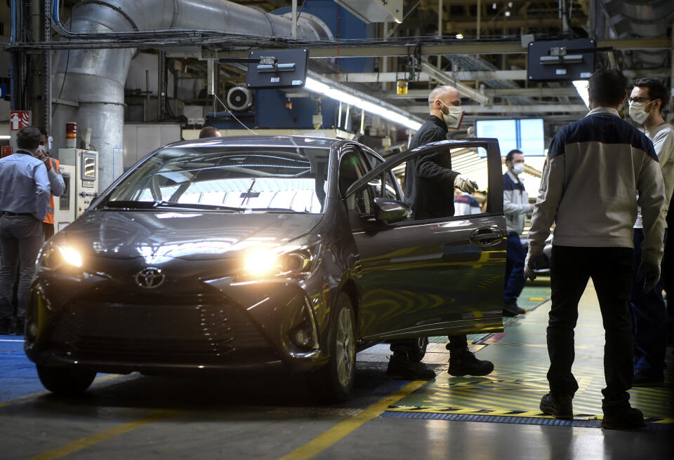 Employees of Toyota, wear protective facemasks and gloves as they work on vehicles at the assembly line of the Toyota automobile plant in Onnaing, near Valenciennes, on April 23, 2020, as the factory reopened after more than a month break aimed at curbing the spread of the COVID-19 (novel coronavirus). (Photo by FRANCOIS LO PRESTI / AFP)