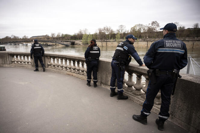 Des agents de sécurité de la ville de Paris patrouillent sur les quais de la Seine, en mars 2020.
