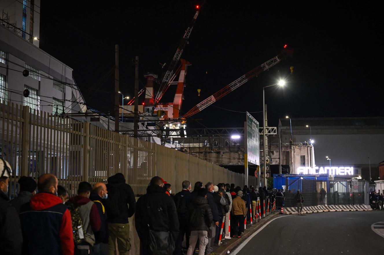 Des travailleurs font la queue, attendant le contrôle de leur passe sanitaire, le 15 octobre 2021, à l’entrée du chantier naval Fincantieri, dans le port de Gênes, en Italie.