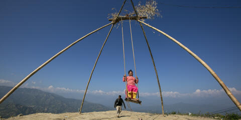 A Nepalese woman rides a swing set up as part of festivities for Dashain in Dhulikhel, outskirts of Kathmandu, Nepal, Tuesday, Oct. 12, 2021. Dashain, the most important religious festival of Nepal's Hindus, commemorates the victory of the gods over demons. (AP Photo/Niranjan Shrestha)