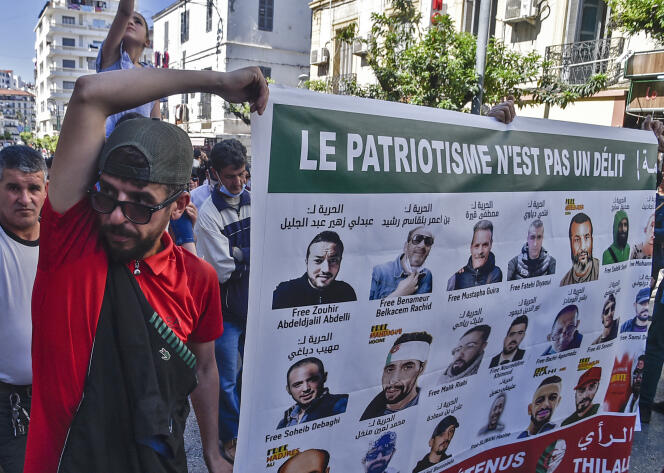 Des manifestants antigouvernementaux portent une affiche figurant des militants emprisonnés, à Alger, le 7 mai 2021.