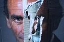 This photograph taken on October 20, 2021 shows a torn poster of French far-right media pundit Eric Zemmour in Paris. (Photo by JOEL SAGET / AFP)