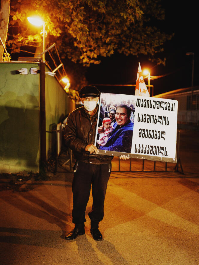 Devant la prison numéro 12 où Mikheil Saakachvili, l’ancien président géorgien est emprisonné depuis son retour en Géorgie. Un supporter de M. Saakachvili brandit une pancarte devant les caméras des télévisions géorgiennes : « Liberté ! pour Saakachvili le bâtisseur de la patrie ». Roustavi, Géorgie, 19 octobre 2021.