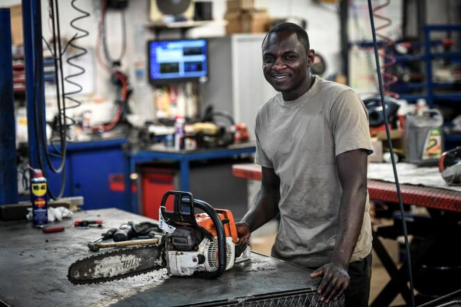 Adam Osman, Tchadien d’origine, pose dans l’atelier de l’entreprise où il travaille en tant que mécanicien, à Bonnelles (Yvelines), en août 2018.