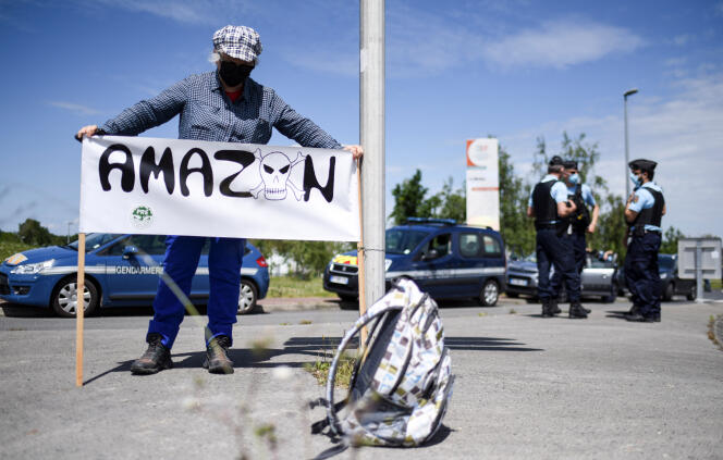 Une femme opposée à l’installation d’Amazon à Montbert, près de Nantes, brandit une pancarte, le 29 mai.