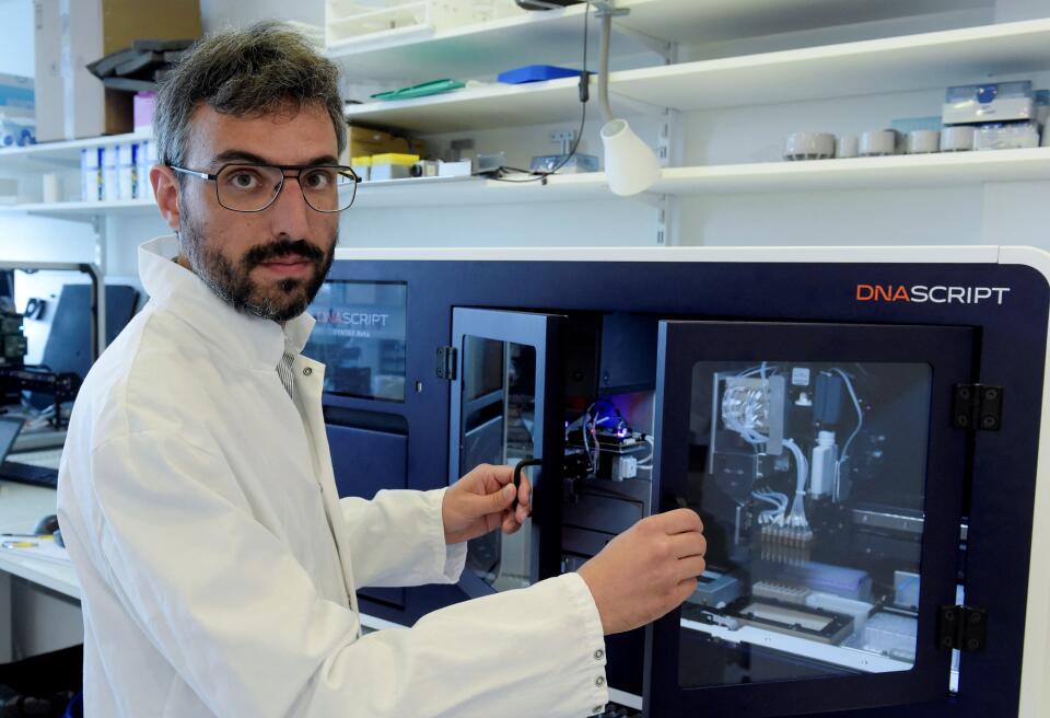 DNA Script co-founder and CEO Thomas Ybert poses in front of DNA Script's world first benchtop DNA printer on August 28, 2020 in Kremlin-Bicetre, near Paris. - In a laboratory in the south of Paris, searchers from the biotechnology company DNA Script are developing a "printer" to create from scratch synthetic DNA fragments that can be used by laboratories. (Photo by ERIC PIERMONT / AFP)