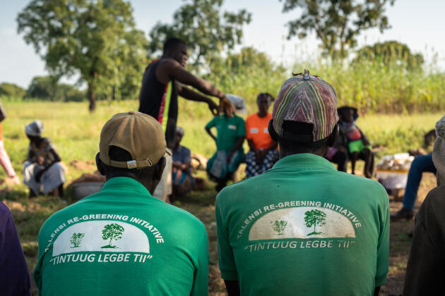Victor, agriculteur à Talensi (Ghana), informe des membres de la communauté de Shea Dazoya, le 12 octobre 2021. « Tintuug Legbe Tii » inscrit derrière les chemises des deux hommes se traduit par « Un arbuste devient un arbre ».