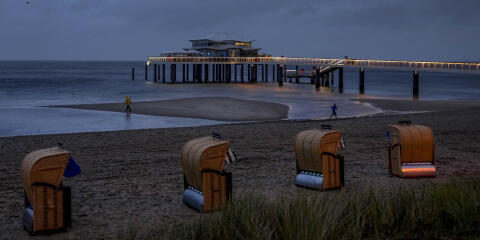Last beach chairs stand at the beach of the Baltic Sea in Timmendorfer Strand, Germany, on a rainy and stormy Friday morning, Oct.22, 2021. (AP Photo/Michael Probst)