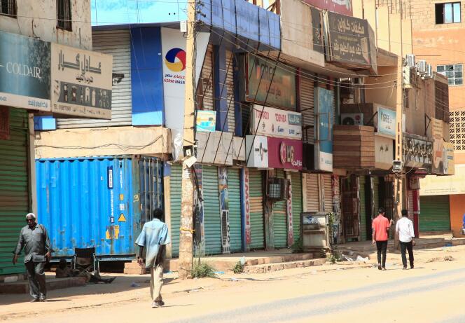 People walk past closed shops in the Sudanese capital on October 28, 2021, four days after the coup.