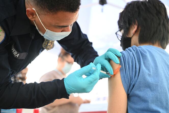 Un soignant administre une deuxième dose du vaccin de Pfizer-BioNTech contre le Covid-19 à un jeune de 16 ans, à Los Angeles, en Californie, le 23 août 2021.