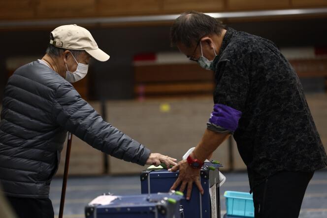 Un elettore giapponese fa scorrere il suo voto alle urne a Tokyo il 31 ottobre 2021.