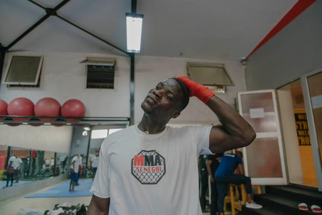 Alois Sambo s’étire pendant un entraînement dans la salle de sport de Kebe, en centre-ville de Dakar, le 24 octobre 2021.