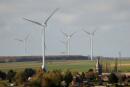 Power-generating windmill turbines are seen behind a church in the village of Inchy-en-Artois, France, November 1, 2021. REUTERS/Pascal Rossignol