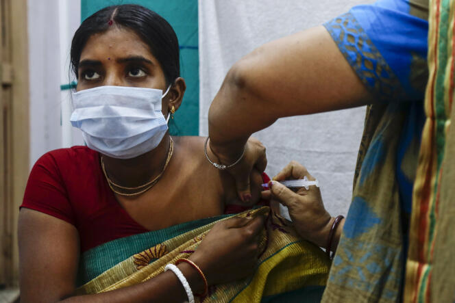 Health workers administer a dose of Covaxin vaccine, Garia, India, October 21, 2021.