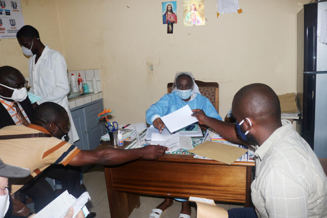Un patient présente ses résultats positifs au test de dépistage du Covid-19 à l’hôpital catholique Saint-Paul, à Douala, le 9 juin 2020.