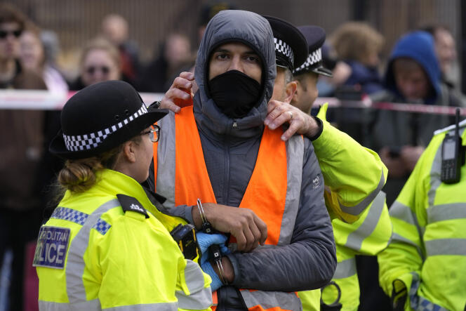 Un militant d’Insulate Britain est arrêté après avoir été décollé du toit d’un fourgon de police, devant le Parlement de Londres, le 4 novembre 2021.