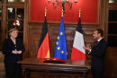 German Chancellor Angela Merkel reacts as French President Emmanuel Macron applauds as she is awarded with the Grand Cross of the Legion d'Honneur, in Beaune, Burgundy, Wednesday Nov. 3, 2021. German Chancellor Angela Merkel will be feted by France in a special farewell ceremony honoring her leadership and partnership. Merkel is leaving office after 16 years in power. (Philippe Desmazes, Pool Photo via AP)