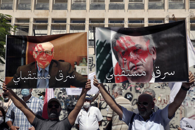Une pancarte représentant Riad Salamé (à droite), barrée de l’inscription « A volé mon avenir », devant la Banque centrale, à Beyrouth, le 6 octobre 2021.