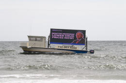 BELMAR, NEW JERSEY - SEPTEMBER 05: Protect Our Care, one of the nation's leading health care advocacy organizations, present a floating billboard during Labor Day weekend at the New Jersey shore on September 05, 2021 in Belmar, New Jersey, urging Senator Menendez and Rep. Gottheimer to support legislation to lower prescription drug prices by giving Medicare the power to negotiate for lower prices. The effort is part of Protect Our Care's multi-million dollar campaign to pass health care policies that lower costs and improve care, which are at the heart of President Biden's Build Back Better plan. Dave Kotinsky/Getty Images for Protect Our Care/AFP (Photo by Dave Kotinsky / GETTY IMAGES NORTH AMERICA / Getty Images via AFP)