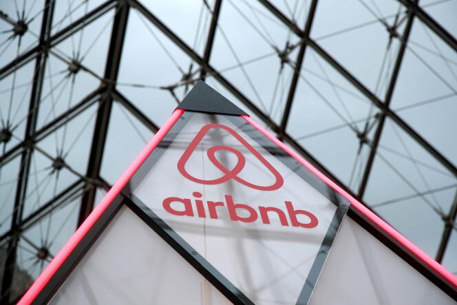 Le logo Airbnb, imprimé sur la pointe d’une structure publicitaire installée sous la pyramide de verre du musée du Louvre, à Paris, en mars 2019.