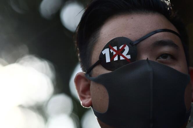 Le militant Luk Nat, qui a perdu la vue d’un œil lors d’une manifestation antigouvernementale, devant la Cour constitutionnelle de Thaïlande, à Bangkok, le 10 novembre 2021.
