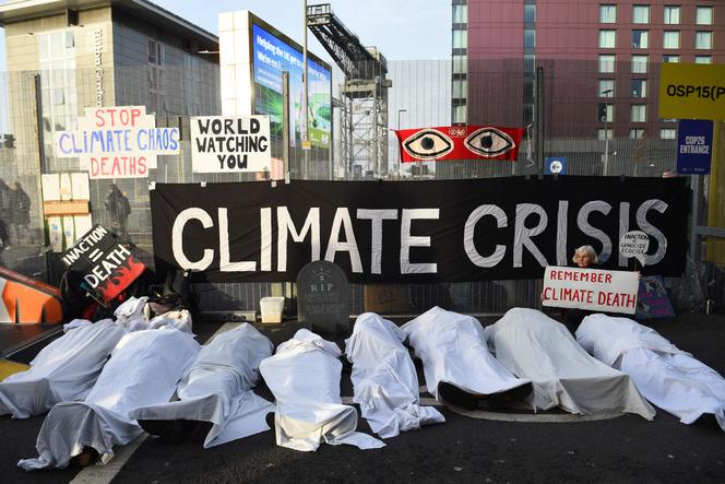 Extinction Rebellion activists lie under white sheets to warn of deaths due to climate change in Glasgow (UK) on November 11, 2021.