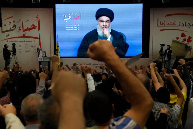 Des soutiens du Hezbollah lèvent le poing devant la retransmission d’un discours du leader du mouvement chiite, Hassan Nasrallah, à Beyrouth, le 11 novembre 2021.