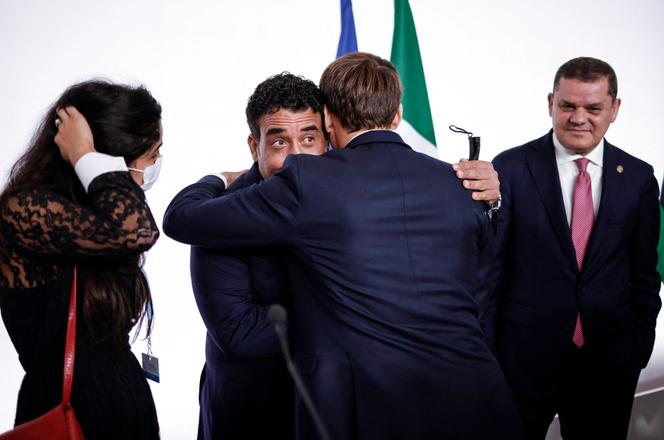 Le président français, Emmanuel Macron, donne l’accolade au président du conseil présidentiel libyen, Mohammed Al-Menfi, sous le regard du chef du gouvernement d’union nationale, Abdel Hamid Dbeibah, le 12 novembre 2021 en marge de la conférence internationale sur la Libye à Paris.