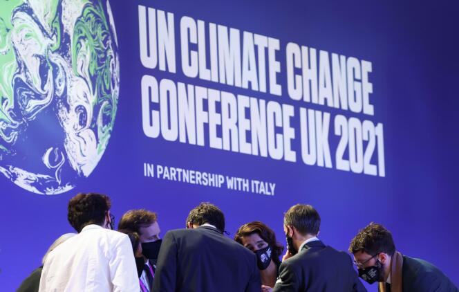 Des délégués discutent pendant la Conférence des Nations Unies sur le changement climatique (COP26) à Glasgow, en Grande-Bretagne, le 13 novembre 2021.