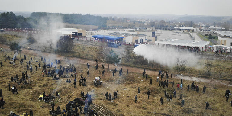 In this image taken with a drone Polish servicemen use a water cannon during clashes between migrants and Polish border guards at the Belarus-Poland border near Grodno, Belarus, on Tuesday, Nov. 16, 2021. Polish border forces say they were attacked with stones by migrants at the border with Belarus and responded with a water cannon. The Border Guard agency posted video on Twitter showing the water cannon being directed across the border at a group of migrants in a makeshift camp. (Leonid Shcheglov/BelTA via AP)