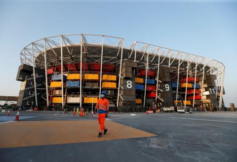 A worker walks in front of Ras Abu Aboud Stadium, one of the venues of the Qatar World Cup 2022, in Doha, Qatar, November 17, 2021. Picture taken November 17, 2021. REUTERS/Hamad I Mohammed