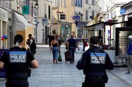 Local police patrol as pedestrians wear face masks in the main street of Sceaux, south of Paris, on April 8, 2020, on the 23rd day of a strict lockdown in France aimed at curbing the spread of the COVID-19 pandemic, caused by the novel coronavirus. - The mayor of Sceaux issued a decree for the mandatory wearing of a face mask or other type of protection over the mouth and nose for outings of people over 10-years-old. (Photo by THOMAS COEX / AFP)