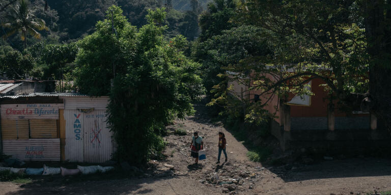 Des habitantes marchent dans une rue de San Antonio Las Flores. 08/06/21 San Antonio Las Flores, Chinautla, Guatemala.