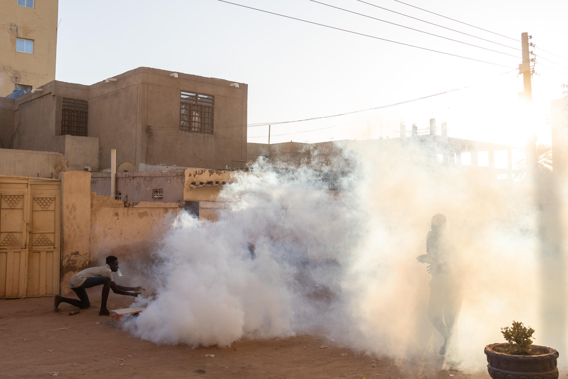 Un jeune essaie d’éteindre des grenades de gaz lacrymogène tombées dans le quartier d’al-Shaabiya, à Bahri, le 18 novembre 2021.