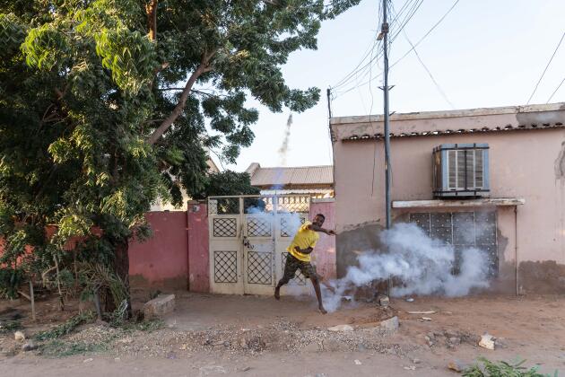 Un habitant renvoie des grenades de gaz lacrymogène à la police dans le quartier d’al-Shaabiya, à Bahri, le 18 novembre 2021.