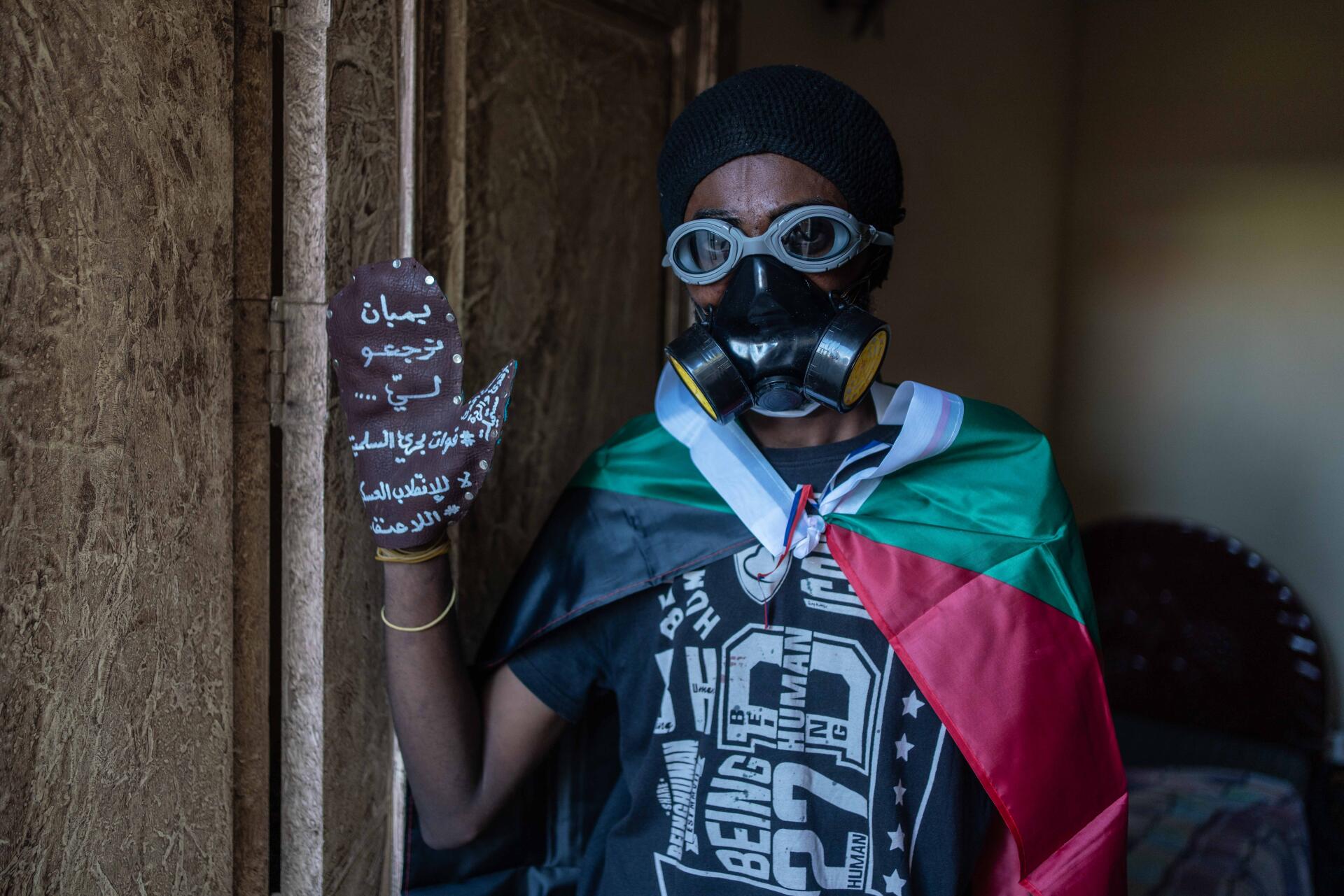 Bahri, le 18 novembre 2021. Moamen, 28 ans, membre d’un comité de résistance, porte un gant sur lequel est écrit : « Les gaz lacrymogènes viennent à moi. Les forces pacifiques de Bahri. Non au coup militaire, non à la violence ». « J’utilise cette moufle pour renvoyer les grenades lacrymogènes. Ce n’est pas de la violence pour moi, ce pouvoir nous tue avec des balles réelles », dit-il.