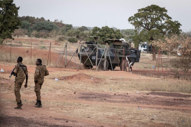 Des officiers de l’armée du Burkina Faso patrouillent près d’un véhicule blindé de l’armée française, à Kaya, après que des manifestants ont bloqué le passage d’un convoi militaire le 20 novembre 2021.