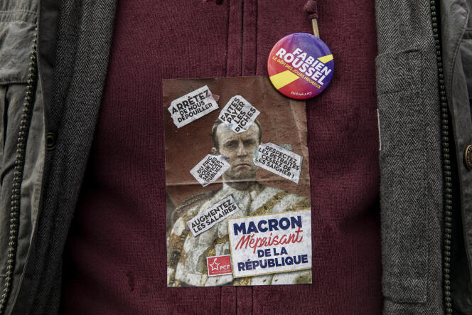Un sticker « Macron méprisant de la République » côtoie un écusson « Fabien Roussel » sur le torse d'un militant, place Stalingrad, le 21 novembre 2021.