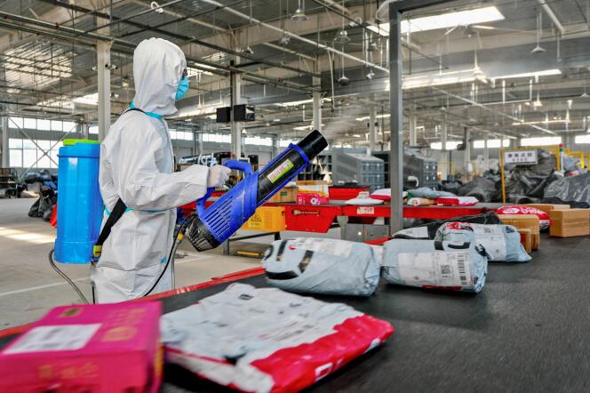 Un employé d’une entreprise de logistique pulvérise du désinfectant sur des colis à livrer, à titre préventif, à Zhangye, en Chine, le 16 novembre 2021.