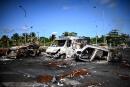 TOPSHOT - This photograph taken on November 23, 2021 shows barricades made of burnt cars at Montebello roundabout in Petit-Bourg, on the French Caribbean island of Guadeloupe following days of rioting against Covid-19 measures. (Photo by Christophe ARCHAMBAULT / AFP)