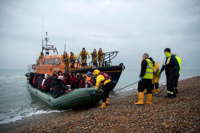 Migrants disembark from a Royal National Lifeboat Institution (RNLI) rescue boat at a beach in Dungeness, on the south-east coast of England, on November 24, 2021, after being rescued while crossing the Handle.  On the same day, at least 31 migrants died trying to cross the Channel from Calais to England.