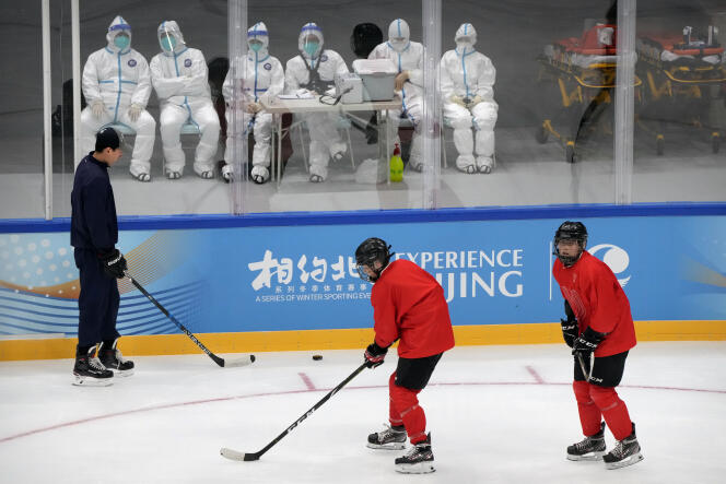 Du personnel médical en combinaison de protection pendant l’entraînement de l’équipe de hockey du China Ice Sports College lors de l’Experience Beijing Ice Hockey Domestic Test Activity, à Pékin, le 10 novembre 2021.