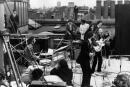 30th January 1969: British rock group the Beatles performing their last live public concert on the rooftop of the Apple Organization building for director Michael Lindsey-Hogg's film documentary, 'Let It Be,' on Savile Row, London, England. Drummer Ringo Starr sits behind his kit. Singer/songwriters Paul McCartney and John Lennon perform at their microphones, and guitarist George Harrison (1943 - 2001) stands behind them. Lennon's wife Yoko Ono sits at right. (Photo by Express/Express/Getty Images)