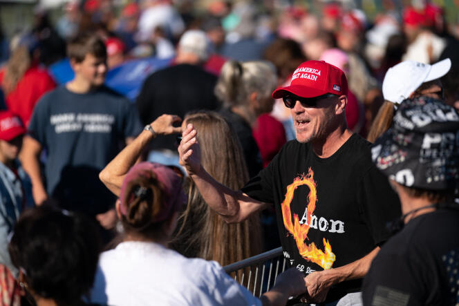 A man in a QAnon T-shirt waits for Donald Trump on September 25, 2021, in Perry, Georgia.